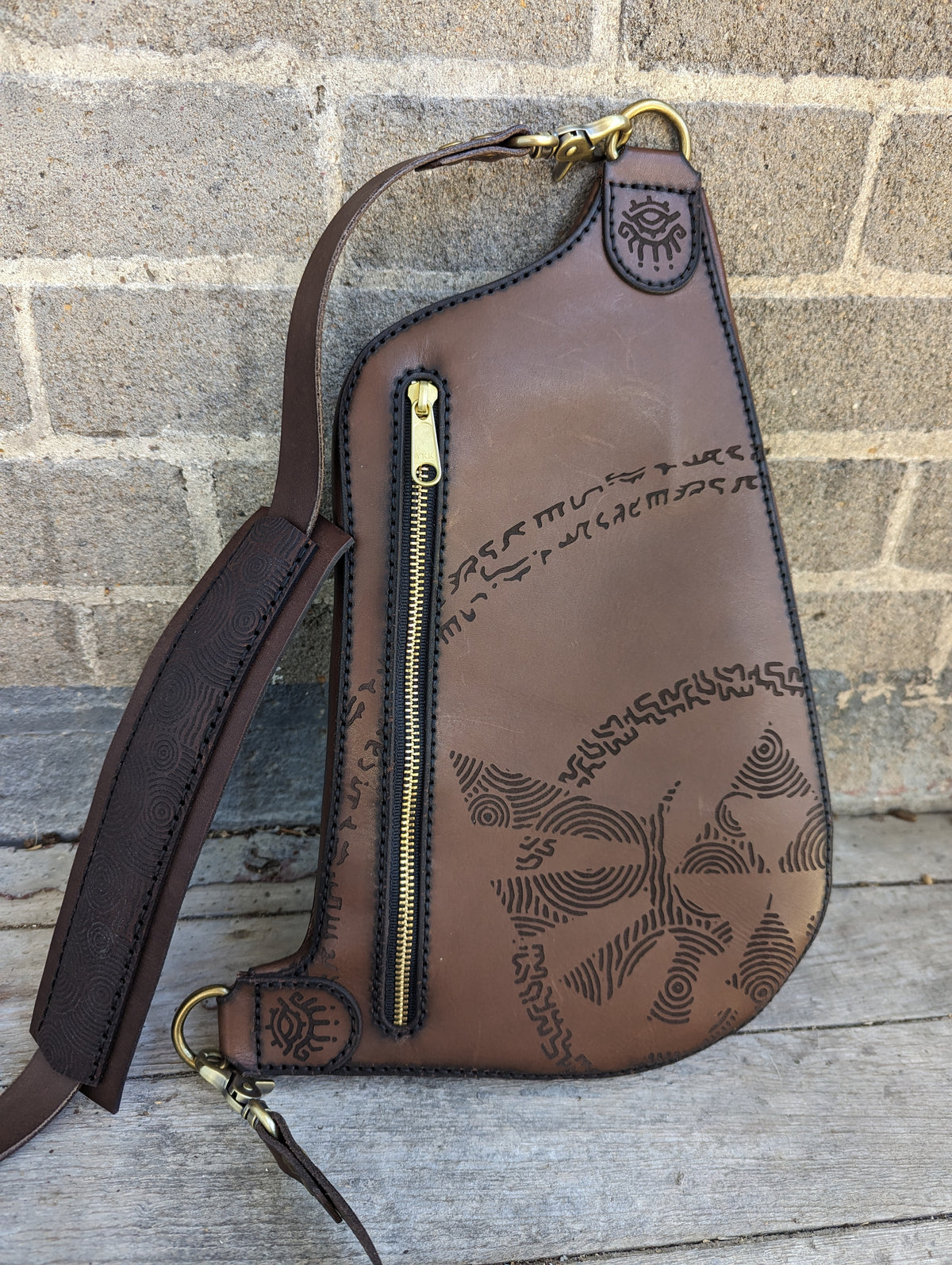 Handcrafted full grain leather crossbody sling bag with laser engraved ancient slate runic graphics and front vertical zipper
